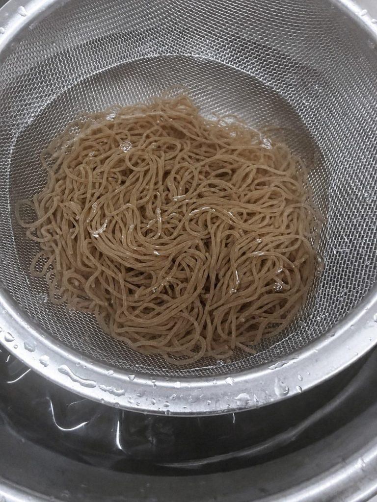 ざるに入れて冷水で締めた冷麺の麺
